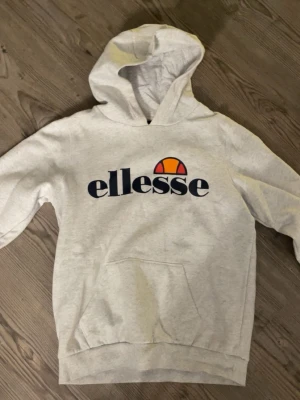 Ljusgrå Ellesse hoodie med logga - Chill ljusgrå hoodie från Ellesse. Klassisk känguruficka framtill och huva. Använd fåtal gånger 💓