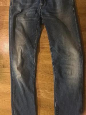 Blå bootcut jeans med slitningar - Säljer ett par blå replay jeans med snygga slitningar och fransade benslut. Perfekta för dig som gillar en avslappnad och trendig look.                  Pris kan diskuteras.