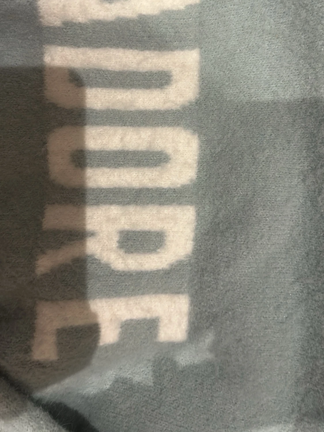 Ljusblå stickad tröja med text - 1