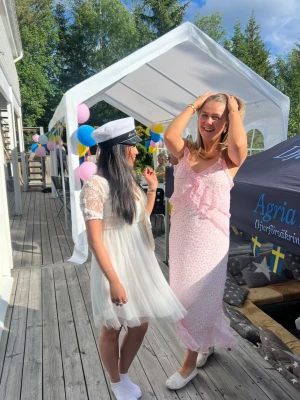 Lång rosa blommig volangklänning - Söt långklänning i ljusrosa med små blommor och volangdetaljer. Klänningen har smala axelband, v-ringning och en slits på sidan. Perfekt för sommarens alla tillfällen. Köpt på vero Moda för 600-800 kronor, storlek S. Använd 2 gånger