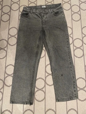 Grunt Jeans - Ett par grå jeans från grunt, klassisk 5-ficksdesign, loose fit och raka ben, storlek 164 (27)kan vara lite stora i storleken. Dom har en liten slitning vid vänster smalben(se närmre på bild 2) men annars är dom i fint skick. Perfekta om du gillar jeans som är åt det lite mer baggy hållet och gillar en avslappnad stil. Priset är inte hugget i sten, har nån frågor så är det bara att höra av sig!