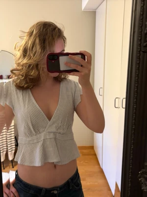 Vit och blå randig topp - Säljer en snygg vit och blå randig topp med knyte i ryggen. Toppen är köpt på hm och är i storlek S. Den är aldrig använd och har prislappen kvar❤️