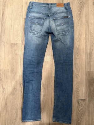 Nudie Jeans Thin Finn Blå W30 L34 - Mycket fint skick. Storlek W30/L34. Mått - Midja: 39,5cm, Ytterbenslängd: 110,5cm, Benöppning: 16,5cm. Modellen är 185cm & 63kg. Hör av dig vid funderingar!🤝