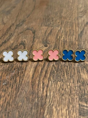 Flerfärgade fyrklöver örhängen - örhängen i form av fyrklöver, i färgerna örhängen har guldfärgad kant och är tillverkade i metall Perfekta för dig som vill variera din stil med färgglada accessoarer.ett par 39 kr.