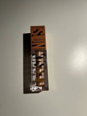 Maybelline highlighter Kiss of Shimmer - Highlighter från Maybelline i nyansen 20 Kiss du Shimmer från Sun Kissed serien. Perfekt för att ge ansiktet en snygg glow och highlighta kindbenen.