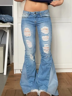 Lågmidjade jeans med slitningar  - Säljer dessa lågmidjade jeans med slitningar på benen. Jeansen är omsydda till bootcut och midjemått 37 cm innerbenslängd 73 cm. Kontakta mig gärna privat vid frågor eller liknande 💕💕