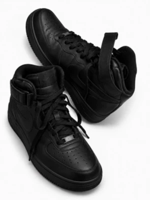 Nike Air Force 1 High Svarta Sneakers - Svarta Nike Air Force 1 High sneakers i läder med klassisk hög siluett, snörning och justerbar rem runt ankeln. Swoosh-logga på sidan och perforerad tå för extra ventilation. Perfekta för dig som gillar en clean och tidlös streetstil.