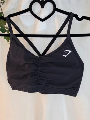 Sport BH - Svart sport BH från Gymshark, korsad rygg och uttagbar inlägg. Har 2 st av dessa så hojta om du vill köpa båda eller bara 1 😊 