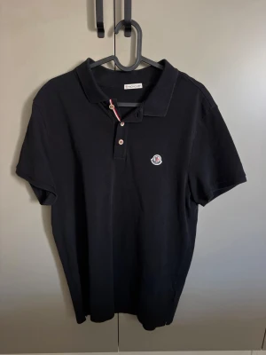 Moncler piké (äkta) - Säljer nu min Moncler pike. Den är i storlek L, då Monclers storlekar är små passar och sitter den mer som en M. Den är självklart 100% äkta, vilket man kan se i annonsen. Väldigt bra skick! Få tecken på användning och har mycket kvar att ge! Nypris på denna är 3000-4000:- mitt pris 1000:- Hör av er vid frågor och funderingar!