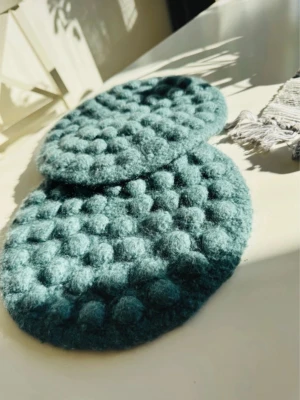 Tovade underlägg - Två stycken tovade underlägg gjorda av mig. Härlig färg. Cirka 25 cm i diameter