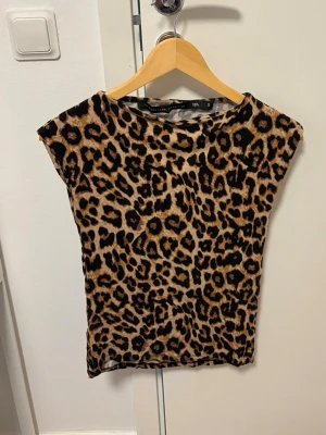 Trendig leopardmönstrad topp från Lager 157 – Strl S - Leopardmönstrad topp från Lager 157 i storlek S. En tidlös och trendig favorit som passar perfekt till både jeans och kjol. Mjukt och skönt material med en smickrande passform. Fint skick och sparsamt använd. Ett snyggt plagg som lyfter vilken outfit som helst! 🐆✨