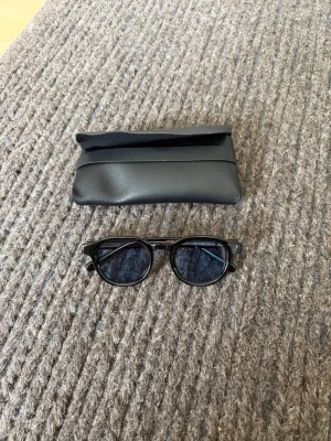 Solglasögon  - Snyggt och stilrent svart fodral till solglasögon i ett mjukt material med enkel design. Perfekt för att skydda dina shades i väskan eller fickan.