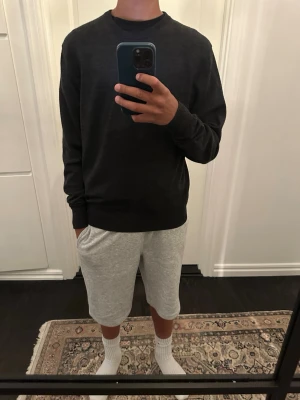 Mörkgrå stickad tröja Uniqlo - Säljer en mörkgrå stickad tröja med stilren passform. Klassisk design utan synliga loggor eller detaljer. Storlek är xs och jag är 165