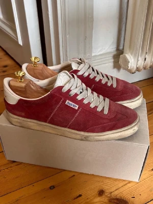Röda Golden goose soul star sneakers i mocka - Snygga röda sneakers från golden goose  i mjuk mocka med vita detaljer och vita skosnören. Låg modell med klassisk retrostil och beige sula. Perfekta för dig som gillar en stilren och sportig look.