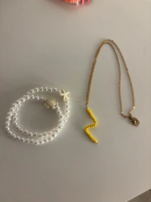 Pärlarmband med sköldpadda & sjöstjärna - Säljer två stretchiga armband med vita pärlor och detaljer i form av en sköldpadda och en sjöstjärna. Också ett halsband med en söt blixt i pärlor!🥹🩷
