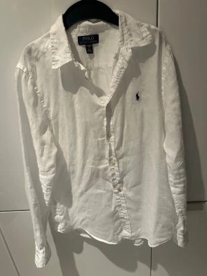 Vit linneskjorta från Polo Ralph Lauren - Vit linne Ralph lauren skjorta i storlek XL i barn. Tveka inte på att höra av dig vid frågor.