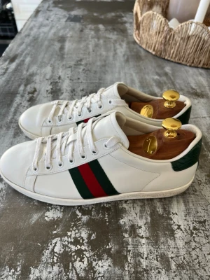 Gucci vita sneakers med ränder - Säljer mina Gucci Ace som är i mycket bra skick de är storlek 38 men är ungefär som 39
