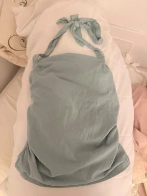 Ljusblå ärmlös linnetopp - Supersöt ljusblå linnetopp med knyt i nacken. Toppen är ärmlös och har en enkel, clean design som passar perfekt till sommaren. Tillverkad i mjuk bomull för en skön känsla hela dagen.