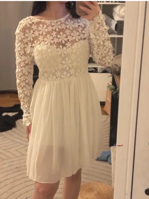 SUPERSNYGG och unik studentklänning❤️ - Superfin vit klänning med långärmad överdel i blommig spets( inbyggd bh) och rund halsringning. Kjolen är lätt och faller snyggt i chiffongliknande material. Perfekt för student eller midsommar! Öppen rygg för extra detalj. Perfekt till studenten❤️Ca 1.60 för referens😊