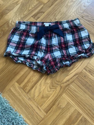 Rutiga pyjamasshorts från Gina Tricot💕💕💕 - Säljer ett par pyjamasshorts från Gina Tricot i rött, blått och vitt rutmönster.💕💕💕💕 Shortsen har en mörkblå rosett framtill och volangkant nedtill💕💕💕I bra skick💕💕💕Jag säljer dem för 40 kr 💕💕💕💕Hör av er vid intresse💕💕💕