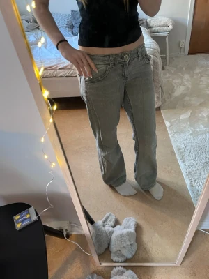 Gråa lösa bootcut jeans med låg midja - Ett par jätte snygga lösa och väldigt lågmidjade jeans som jag inte passar längre. På vissa ställen så är det lite skrynkligt på baksidan av jeansen men man kan säkert få de helt platta med strykjärn. Annars är dom i bra skick och sjukt snygga!💕Jeansen ligger ute på flera ställen