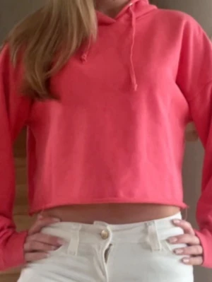 Corallrosa hoodie - Snygg korallrosa cropped hoodie med huva och dragsko. Hoodien har långa ärmar och en avslappnad passform som ger en trendig och sportig look. 