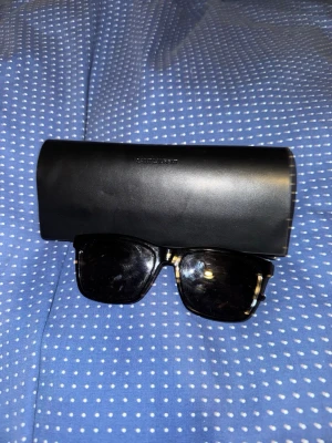 Saint Laurent solglasögon  - Säljer dessa riktigt snygga YSL solglasögon köpt på synsam så självklart äkta kommer med duken och den man lägger glasögonen i, de har en riktigt fett design vid sidorna och är använda ett fåtal gånger men inga defekter och personligen snyggare en rayban boyfreind. Pris kan diskuteras självklart 