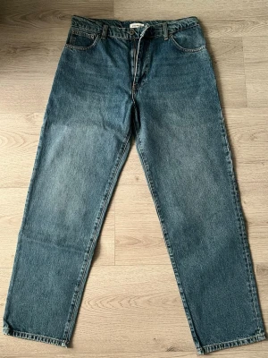 Blå raka jeans från Woodbird - Klassiska blå jeans från Woodbird med rak passform och fem fickor. Jeansen har dragkedjegylf och bälteshällor. Tillverkade i slitstark denim som ger en tidlös look. Perfekta för dig som gillar enkel och clean stil.