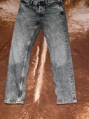 Grå tvättade raka jeans - Snygga grå tvättade jeans med rak passform och klassisk femficksdesign. Jeansen har en cool vintagekänsla och passar perfekt till en avslappnad streetstyle. Tillverkade i bomull för skön känsla hela dagen.