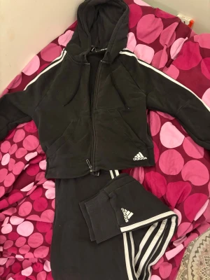 Svart Adidas sett - Svarta mjukisbyxor från Adidas med en svart zip hoodie från Adidas. Perfekta för chill eller träning. Du får hela settet för priset.