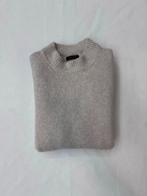 Ljusgrå stickad tröja från Massimo Dutti - Mysig ljusgrå stickad tröja från Arket i klassisk modell med rund halsringning och ribbade muddar vid ärmslut och nederkant. Tillverkad i mjukt material som passar perfekt för kyliga dagar. Axelbredd: 41cm längd: 62cm