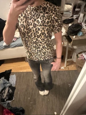 Leopardmönstrad t-shirt från Only - Säljer en leopardmönstrad t-shirt från Only med korta ärmar och rund hals. T-shirten har en beige bas med svarta och bruna leopardfläckar. Perfekt för dig som vill sticka ut lite extra och gillar djurmönster.
