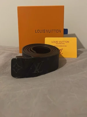 Svart bälte  - Snyggt svart bälte som passar med varenda outfit, tillbringar ett förpackning och ett närvarande kort som innehåller information om märket 