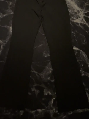 Svarta utsvängda byxor - Säljer ett par svarta utsvängda lågmidjade kostymbyxor..