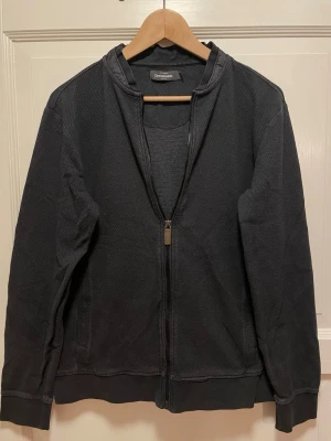 Svart zip hoodie från Dressmann - Säljer en svart hoodie från Dressmann med dragkedja framtill.