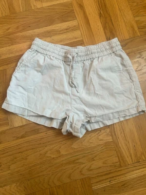Ljusbeiga linneshorts med snörning💕💕 - Säljer ett par ljusbeiga linneshorts med elastisk midja och snörning framtill från Kappahl 💕💕💕Shortsen har en avslappnad passform och är tillverkade i ett mjukt bomullsmaterial💕💕💕I bra skick💕💕Jag säljer dem för 30 kr💕💕Hör av er vid intresse💕💕💕