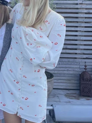 Adoore klänning - Söt vit kortklänning med små röda blommor och knappar framtill. Så fin💕💕💕storlek 34