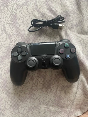 Svart kontroll - Säljer en helt ny svart handkontroll i box.  Perfekt kontroll för spel på flera enheter.  Obs: Detta är inte en originalkontroll från Sony/PlayStation, utan en tredjeparts-kontroll.  Den är testad och fungerar som den ska (alla knappar är fungerande, ingen stick drift)  Jag är inte säker på kompatibiliteten (har testad och fungerar med dator samt telefon men jag är osäker på om det funkar med Xbox eller PlayStation / ps4)  Följer med laddningssladd. Kan skickas med blocket frakt, upphämtning går