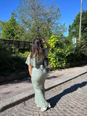 Ljusgrön långklänning m - Säljer min balklänning då jag använt den endast till balen och får ingen använding av den. Klänningen har en figurnära passform och faller snyggt längs kroppen.
