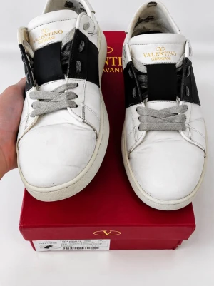 Valentino Garavani vita sneakers - Hej, säljer dessa snygga Valentino Garavani skor i storlek 42. Skorna har tecken på användning och de är sönder under skorna och lite slitage men inget man märker när man har på sig de 😊👍bara skor ingår !