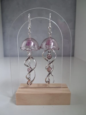 Unika örhängen manet/jellyfish  - Säljer ett par handgjorda örhängen formade som 2st maneter I lila/plommon och silver nyans. Längd ca 6cm långa öronkroken är nickelsäker. Blir en unik accessoar till outfiten 