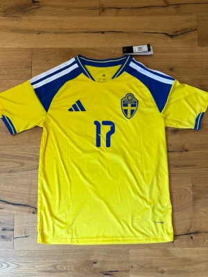 Sverige Hemmaställ VM2026 - Sveriges hemmaställ till Vm2026 med Gyökeres #17 på. FINNS I ALLA STORLEKAR S-XL. Passar både tjejer och killar men de är herrstorlekar.
