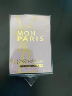 Yves Saint Laurent Mon Paris EdT 90ml - Yves Saint Laurent Mon Paris Eau de Toilette Lumière är en lyxig parfym i en elegant ljuslila kartong med guldiga detaljer. Flaskan rymmer 90 ml och doften är fräsch och feminin, perfekt för dig som gillar exklusiva och moderna parfymer.