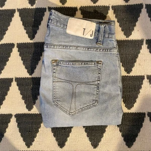 Ljusblå tiger of sweden jeans - Säljer ett par ljusblå skinny jeans från T/J med klassisk femficksdesign och normal midja. Jeansen har en stilren look med diskreta sömmar och är tillverkade i ett mjukt denimtyg som ger en bekväm passform.
