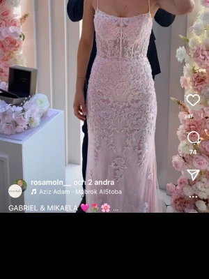 Ljusrosa spetsklänning  - Elegant långklänning/ balklänning i ljusrosa (blush-pink) med smala axelband och vackra spetsdetaljer. Klänningen har figurnära passform och är i mermaidmodell. Använd endast 1 gång under en kväll i några timmar. Orginalpris i butik: 4800 kr. Kemtvättad. 