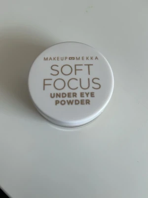 Makeup Mekka Soft Focus Under Eye Powder - Makeup Mekka Soft Focus Under Eye Powder i färgen Soft Banana. Kommer i en rund, vit plastburk med skruvlock. Perfekt för att ljusa upp och fixera området under ögonen. Lätt, finmalt puder som ger en mjuk finish. Oanvänd med plasten kvar på insidan. Nypris 109kr.