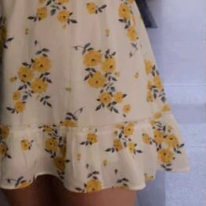 Sommarklänning  - En vit offshoulder klänning med gula blommor och blåa blad, klänning är använd fåtal gånger men är i nyskick. 100kr + 48 kr för frakten 