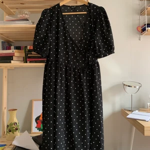 Omlottklänning - Från monki. Bara använd en gång! Knyts omlott med rosetter på sidan. Går ungefär till vaderna på mig som är 160cm lång. Frakt tillkommer!