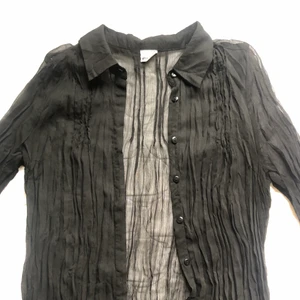 Svart genomskinlig skjorta - Svart genomskinlig skjorta från Gina tricot! Lite krusad framtill.