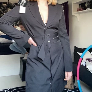 Svart kavajklänning (Nelly) - Svart kavajklänning från Nelly!                          Storlek: 34 (xs/s)                                                Endast testad, fortfarande prislapp kvar         Inget speciellt på ryggen, heltäckande rygg   Köptes för 600, säljes för 470kr                      Fri frakt!!                                                  Skicka privat om du har några frågor💕